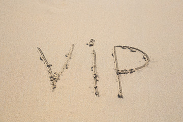 written word VIP on sand of beach