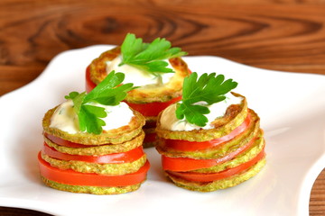 Zucchini appetizer with tomatoes, sauce and parsley. Vegetable snacks for kids. Easy snack to encourage children to eat vegetables. Fried sliced squash with tomatoes, yogurt and parsley. Macro
