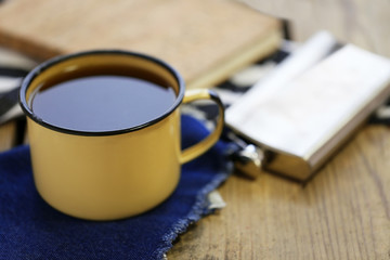 Cup of strong coffee with a flask on a wooden table, close up