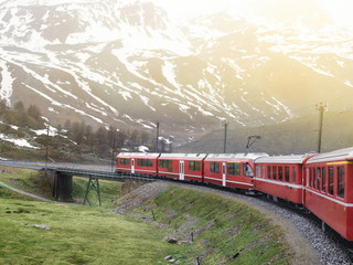 Fototapeta na wymiar Bernina red alpine train crossing bridge