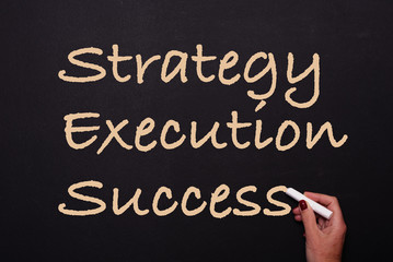 Obraz premium woman is writing on blackboard strategy, execution, success