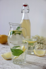 Bicchiere con bevanda di sambuco in primo piano su tavola imbandita