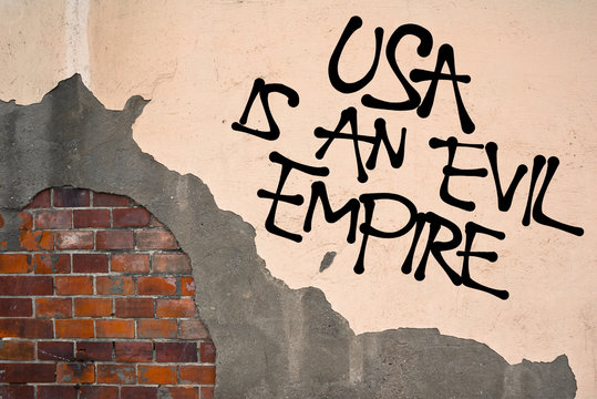 Handwritten graffiti USA Is An Evil Empire sprayed on wall, anarchist aesthetics. Critique of policy of United states - imperialism, neocolonialism, aggression 