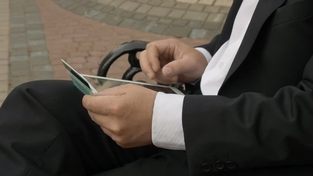 Businessman using his tablet PC to purchase something online with his credit card