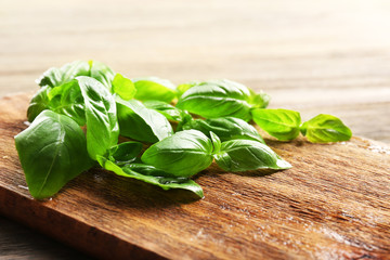 Fresh basil leaves on wooden board