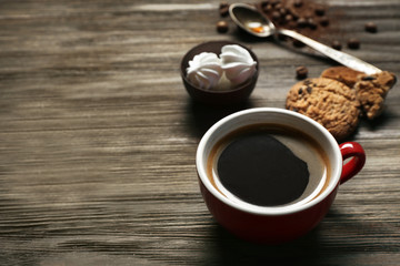Cup of coffee with cookies and zephyr on wooden table