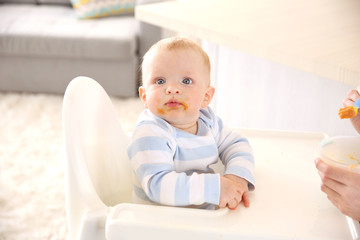 Fototapeta premium Little baby feeding with a spoon