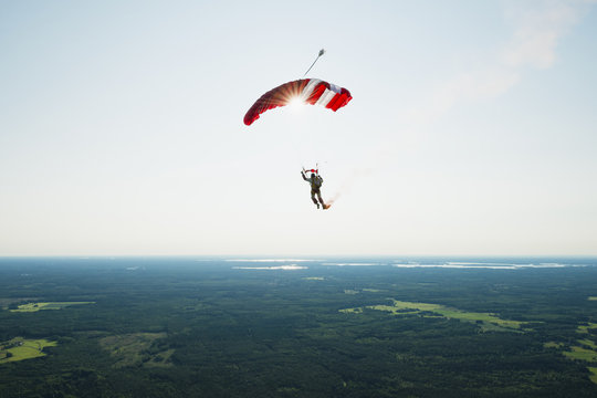 Rear view of man parachuting in air