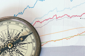 A compass on charts. A direction of success. Shallow dof