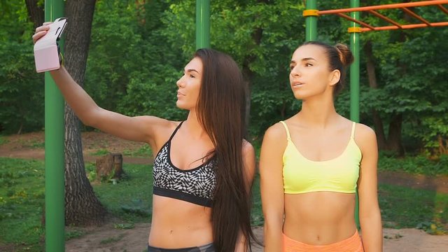 Two girls make merry fitness selfie. Sports figures and good mood.