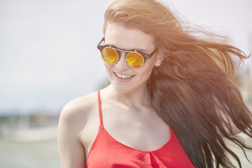 Young woman on the beach in hot summer sun light