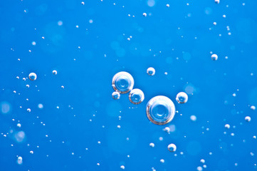 Close-up bubbles under water on blue background. Macro.