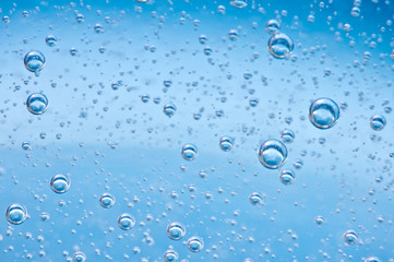 Close-up bubbles under water on blue background.