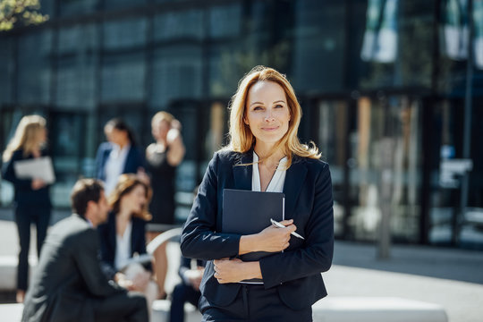 Portrait of smiling businesswoman outside office building