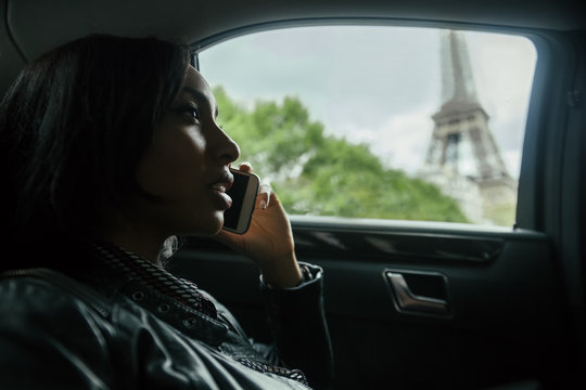 France, Paris, young woman telephoning in a car