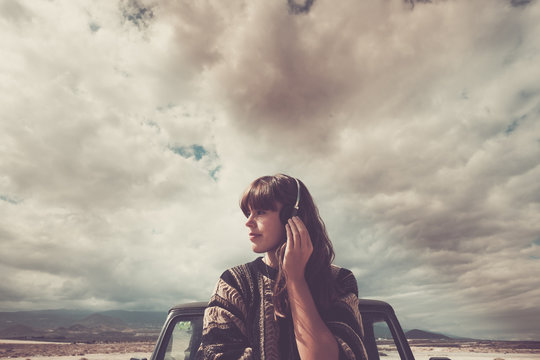 Young woman on the road listening music with headphones