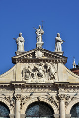 Fototapeta na wymiar Detail of the beautiful St Vincent baroque church in the center of Vicenza, with statue of Jesus, angels and saints (17th century)
