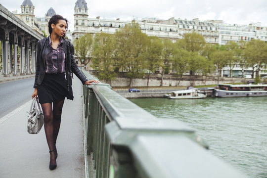 France, Paris, young woman walking on bridge