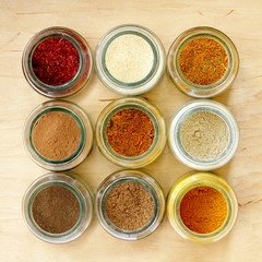 aromatic seasoning for cooking in the kitchen/ many different spices in glass jars, and a special seasoning for pilaf in the middle of a top view 