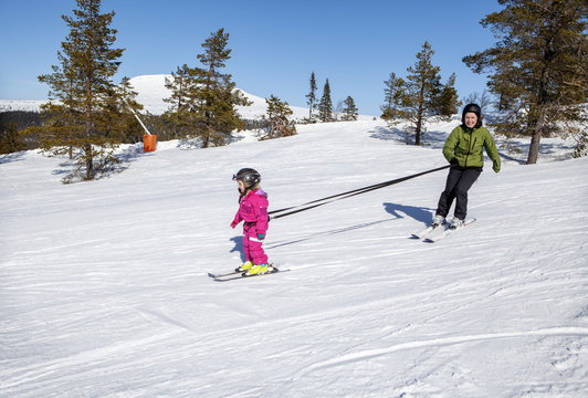Mother teaching daughter skiing