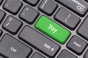 Computer keyboard closeup with "Pay" text on green enter key