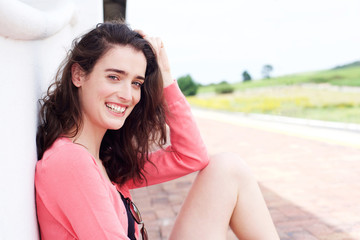 Fototapeta premium Attractive woman sitting outside with hand in hair