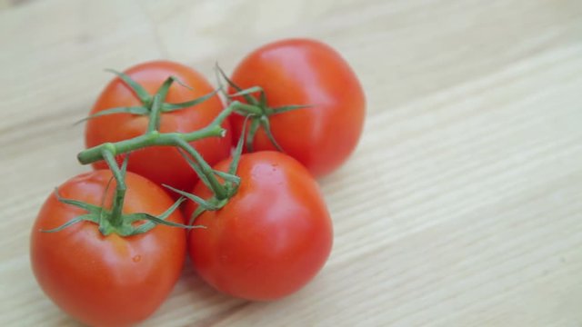 Fresh tomatoes on the vine on wooden table 