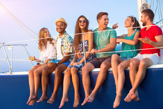 People On Yacht Laughing. Cheerful People Holding Drinks. What A Hilarious Story. Friends Went On A Trip.