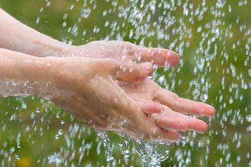 hands washing under rain