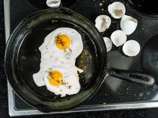 Wall murals Fried eggs Frying eggs in a cast iron pan