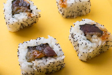 Various kinds of sushi food served on yellow blackground