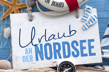 Urlaub an der Ostsee, Nordsee, Meer mit maritimer Dekoration auf blauen Holzhintergrund