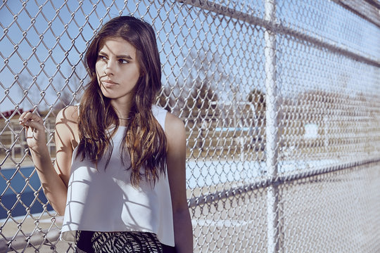 Attractive young woman at a fence