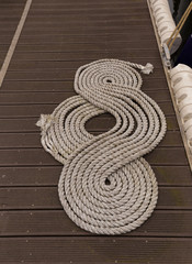 Coil of mooring nautical rope (hemp) folded in helix shape on pier in Ostend, Belgium