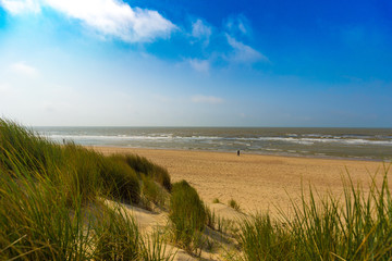 People walking in distance at the Belgian north sea coast near De Haan, Belgium