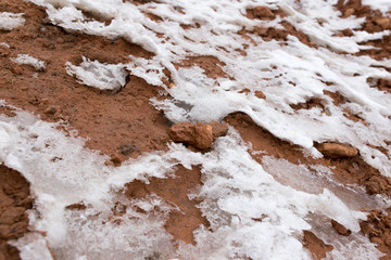 snow on red clay in nature