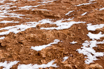 snow on red clay in nature