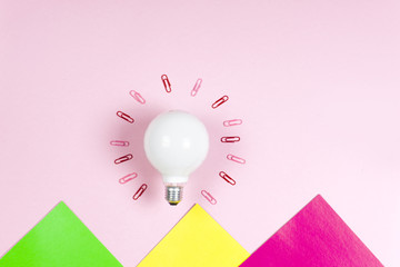 great idea concept with crumpled colorful paper and light bulb on light background. Creative brainstorm concept business idea.  female hand holding light bulb. Copy space for text.