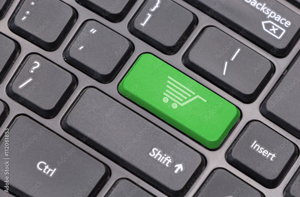 Poster computer keyboard closeup with shopping cart icon on green enter key