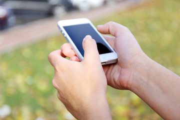 Woman holding smartphone outside