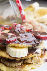 delicious pancakes with nuts, banana, strawberry and chocolate