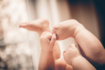 Baby holds his hands their feet close-up