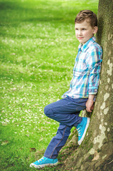 child posing by a tree in the park