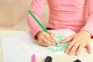 Child drawing tree with pencils on paper, closeup