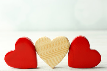 Wooden hearts on light background