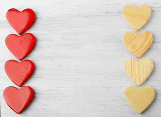 Obraz premium Red and wooden heart shapes on white wood background, love and romance concept, valentine's day celebration