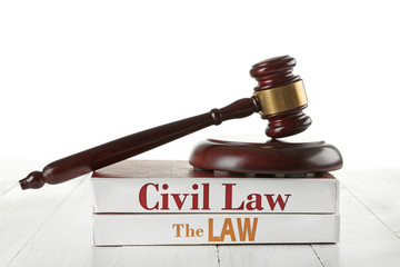Gavel and books on wooden table on white background