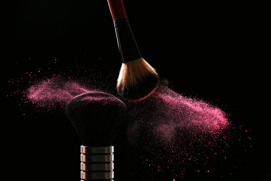 Two Make Up Brushes With Powder On Black Background