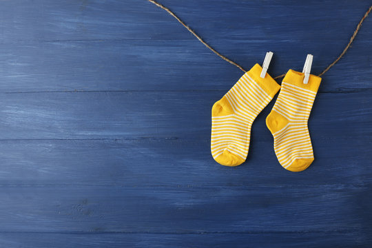 Baby socks hanging on dark blue background