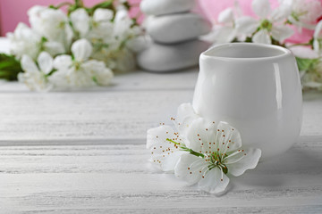 Fototapeta na wymiar Oil with white flowers on wooden table